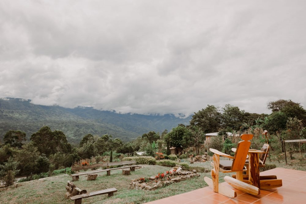 Vista hacia el jardín y al Valle de Tenza desde dos mecedoras en el CHalet de Paja de Luciana Cabañas Boutique.