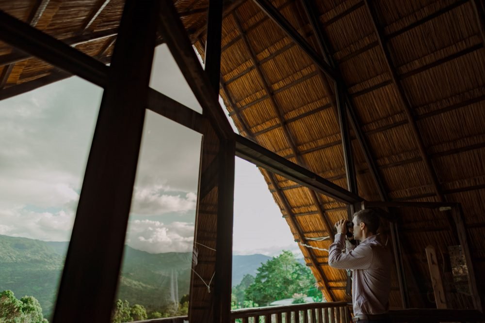 Hombre usando binoculares mirando hacia el Valle de Tenza en el Chalet de Paja.