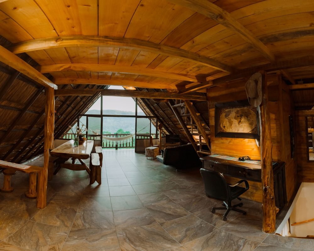 Sala de estar con comedor en madera, espacio para descansar y leer con vista al Valle de Tenza.