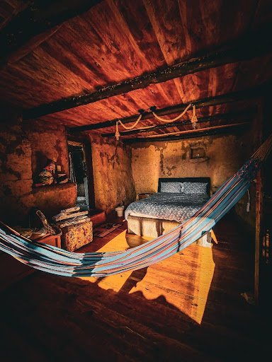 San Sebastian cabaña rústica habitación con cama doble y hamaca