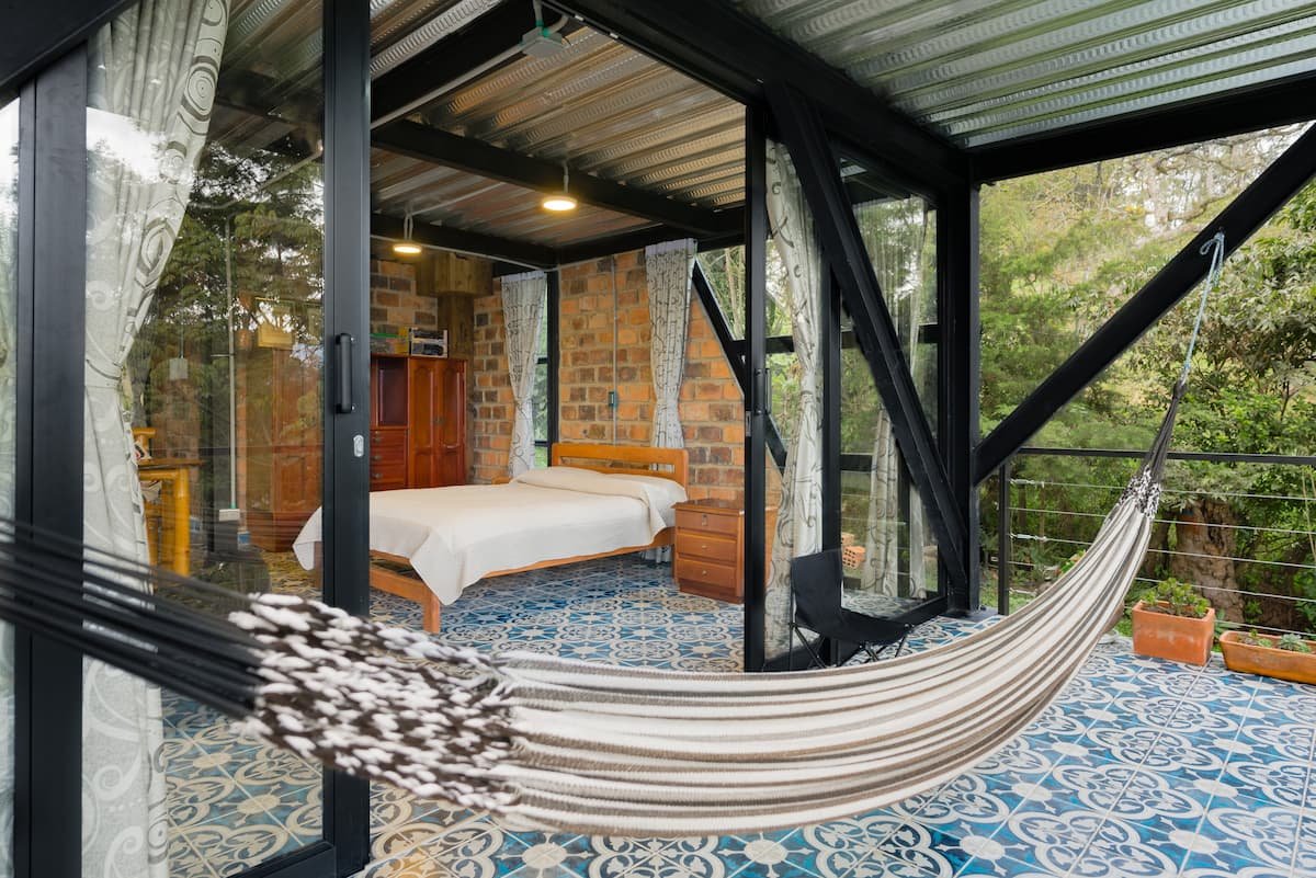 Cama y hamaca en El Estudio, cabaña moderna en Guateque, Boyacá. Luciana Cabañas Boutique.
